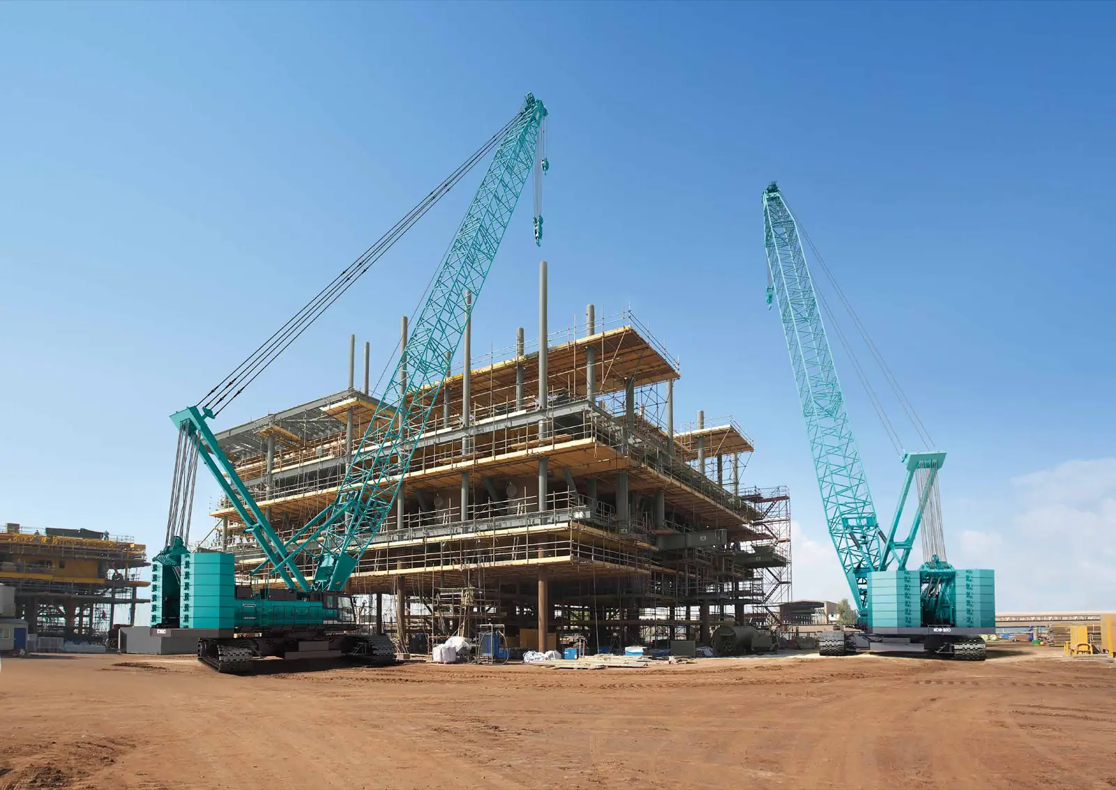 Baureihenbild zu Kobelco CKE2500G-4: Zwei Kobelco Raupenkrane der CKE-G-Baureihe an einem Rohbau
