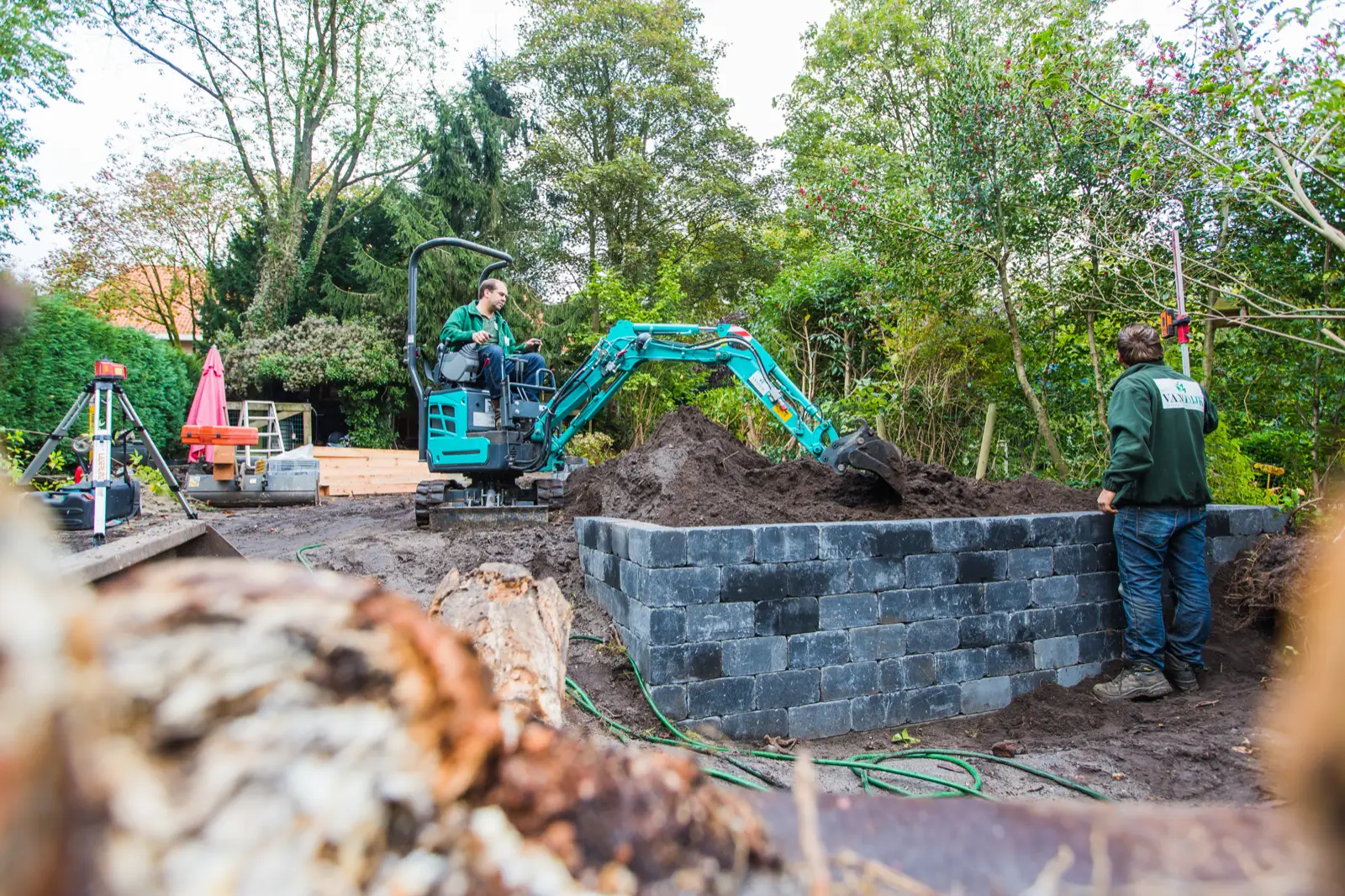 Kobelco SK10SR an einer Gartenmauer