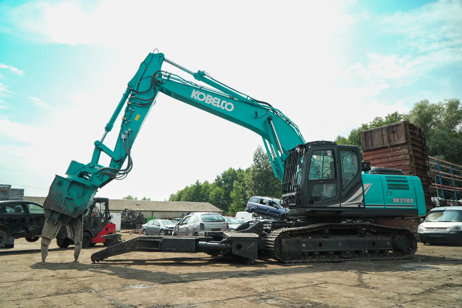 Kobelco SK210D mit Greifzange und Klemmarm auf einem Demontageplatz