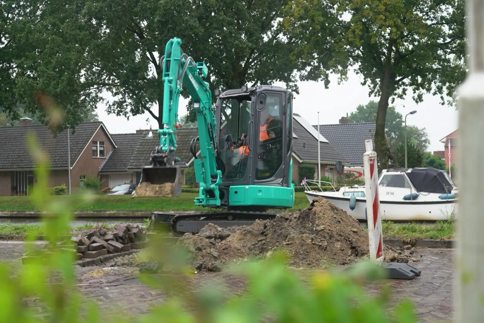 Kobelco SK26SR neben einer gepflasterten Straße