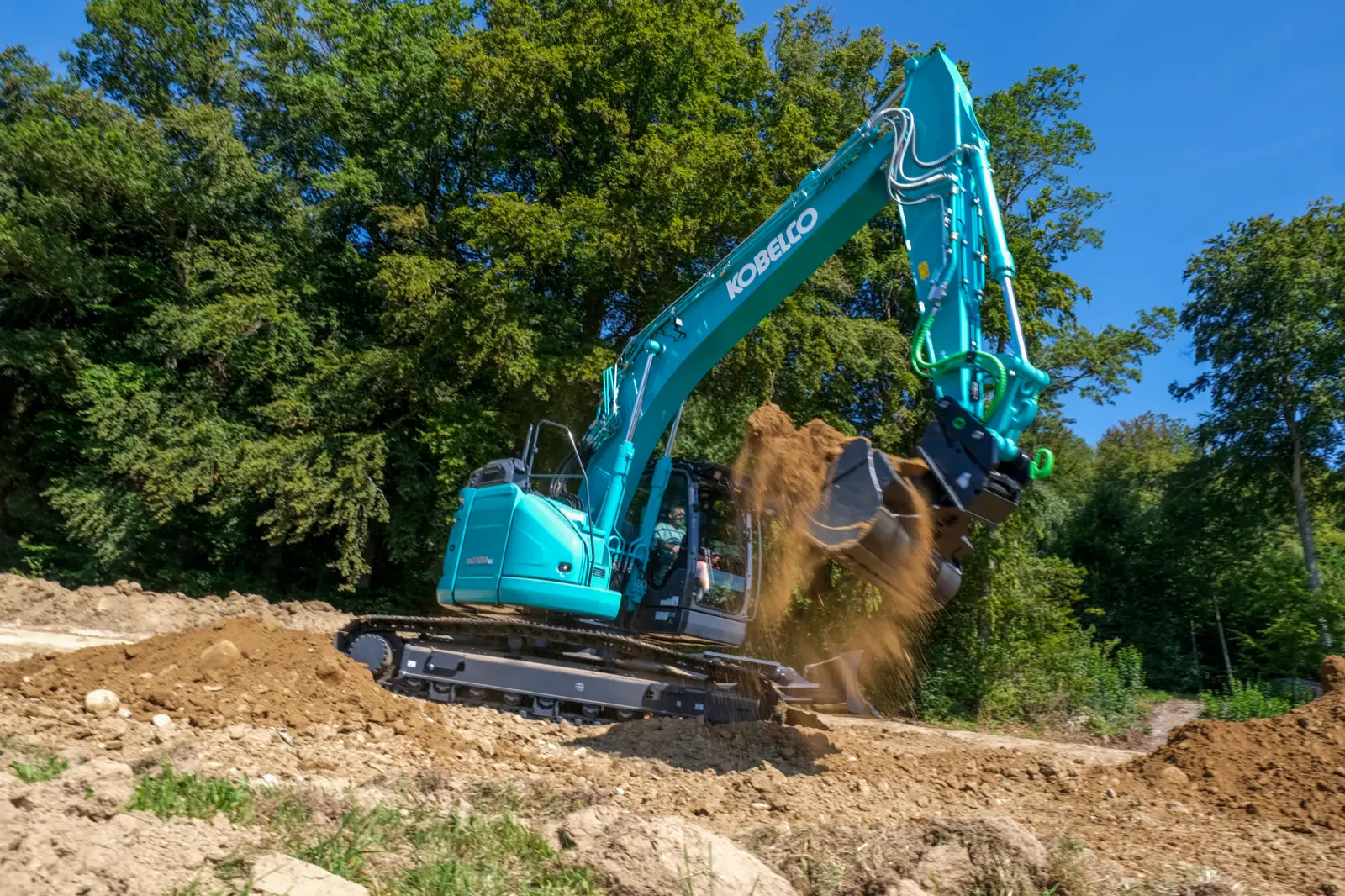 Kobelco Kurzheckbagger der SR-Baureihe mit Tiltrotator beim Auskippen von Erde