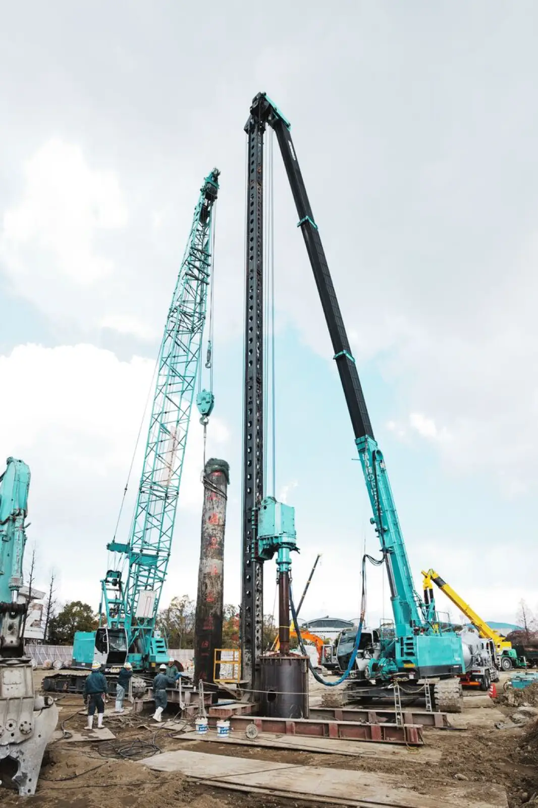 Kobelco Teleskop-Raupenkran mit Mäkler bei Pfahlarbeiten