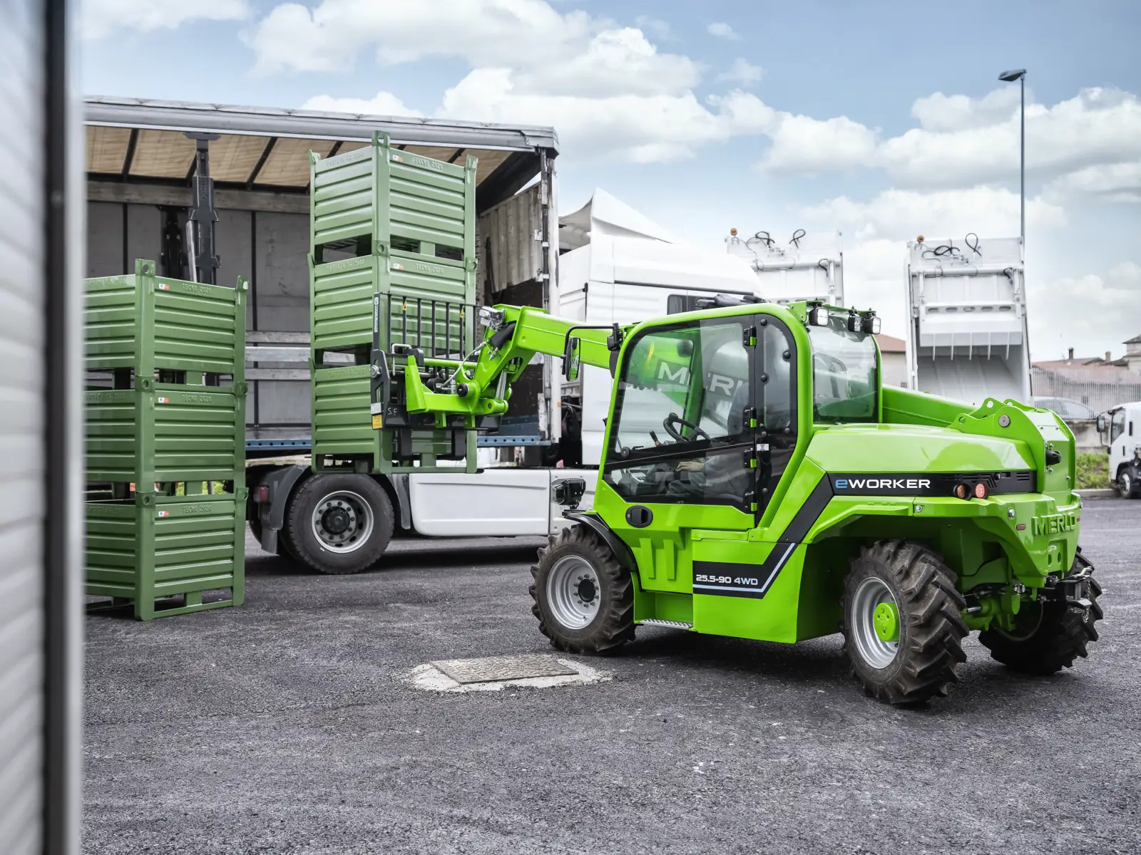 Merlo eWorker EW 25.5-90 4WD belädt einen Lkw mit Gitterboxen