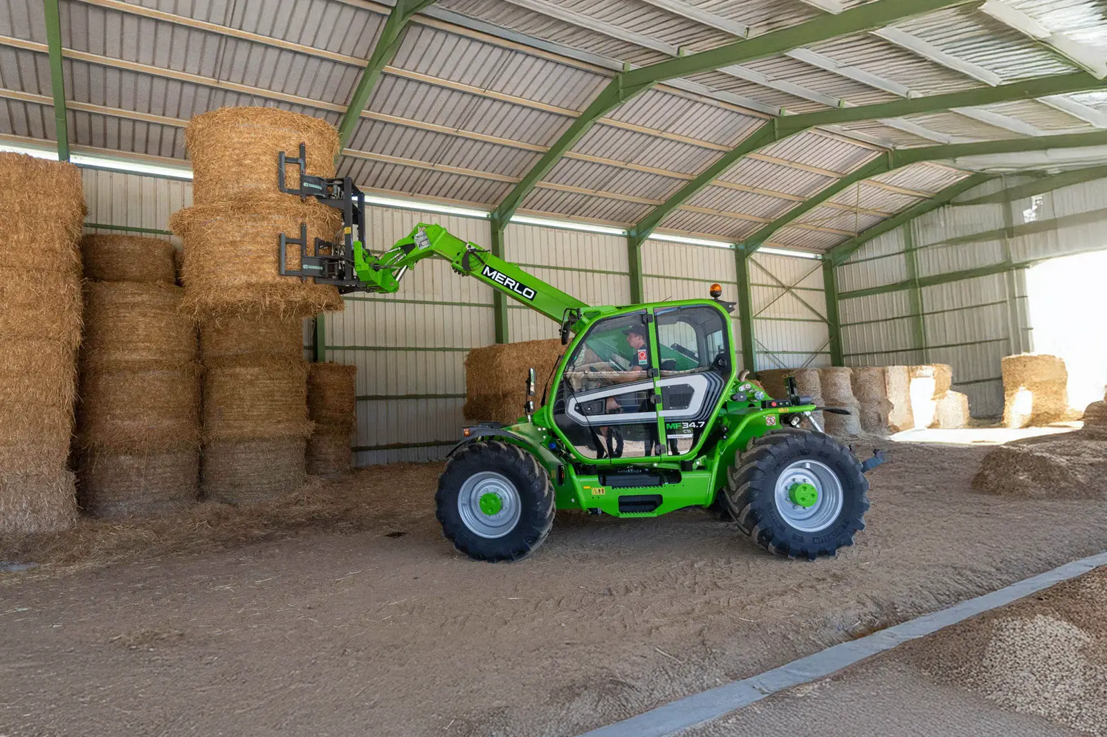 Baureihenbild zu Merlo MF 34.7 CS-140-CVTRONIC: Merlo Multifarmer MF 34 stapelt Quaderballen in einer offenen Halle