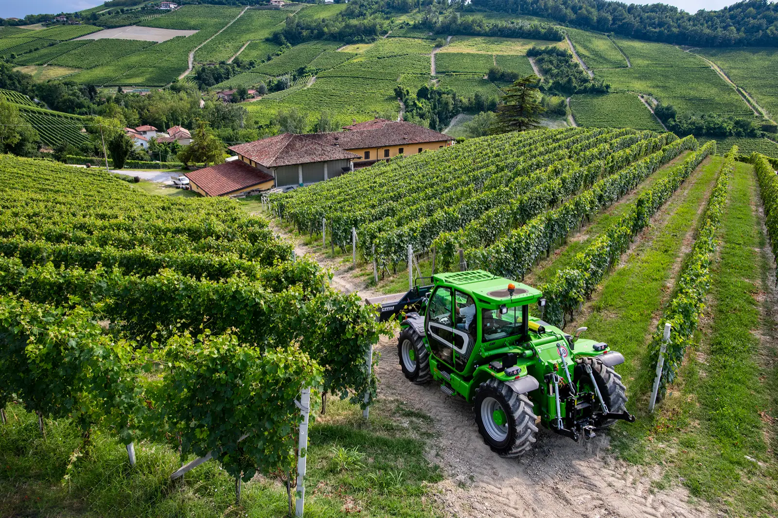 Baureihenbild zu Merlo MF 34.7 CS-140-CVTRONIC: Merlo Multifarmer MF 34 fährt auf einem Weg zwischen Rebzeilen, von oben