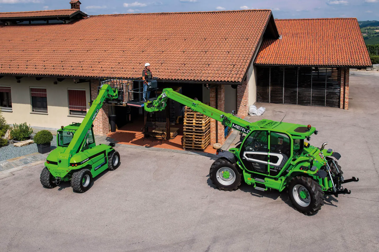 Baureihenbild zu Merlo MF 34.9 CS-140: Zwei Merlo Multifarmer auf einer Hofstelle, einer mit Arbeitsbühne