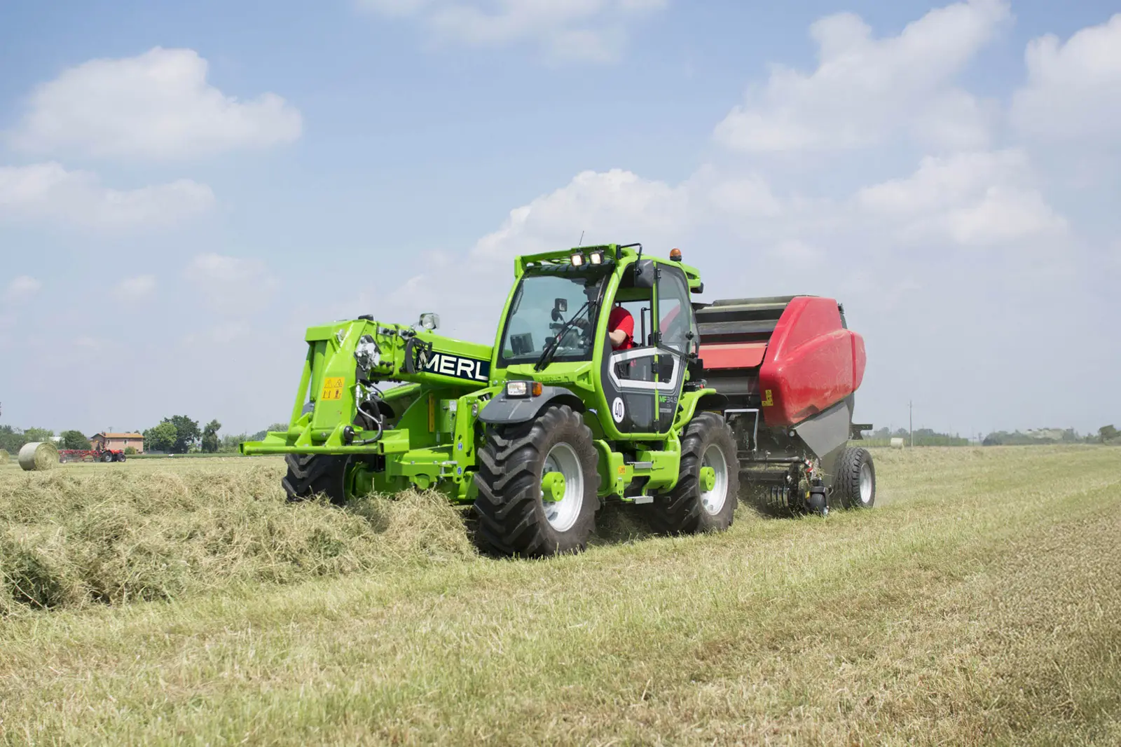 Baureihenbild zu Merlo MF 34.9-140: Merlo Multifarmer MF 34 zieht eine Rundballenpresse über ein Feld