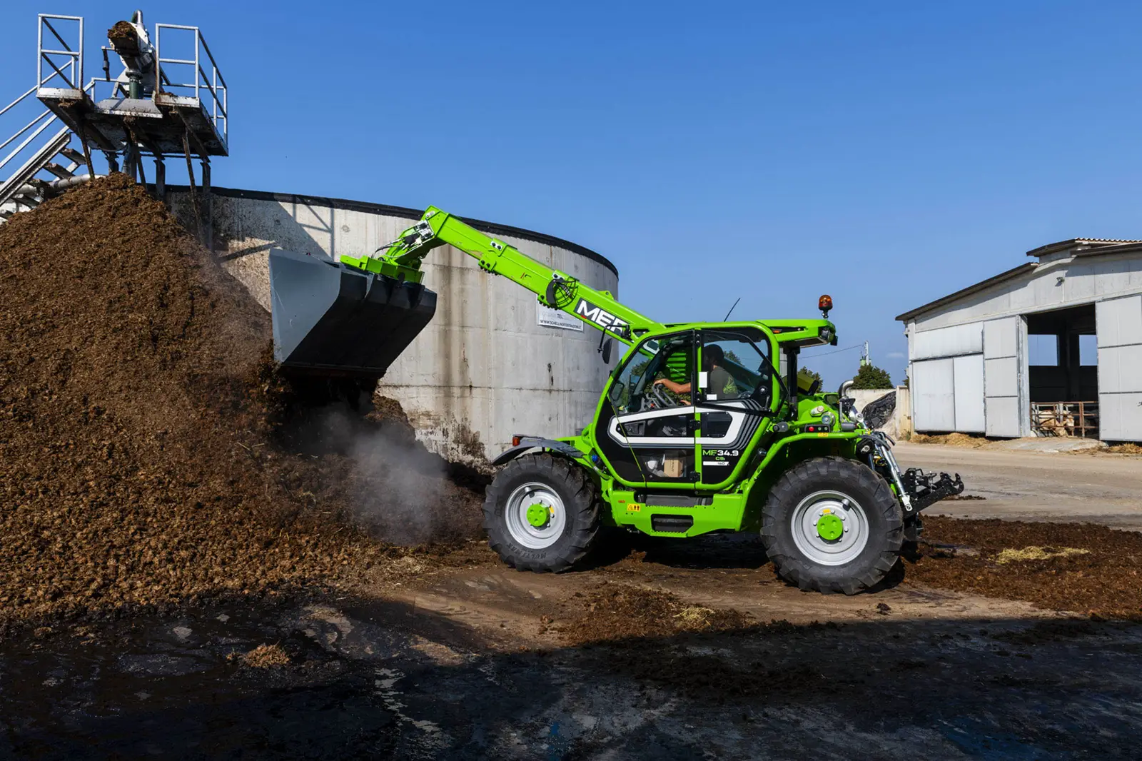Baureihenbild zu Merlo MF 34.9-140: Merlo Multifarmer MF 34 schüttet Material mit der Schaufel in einen Behälter