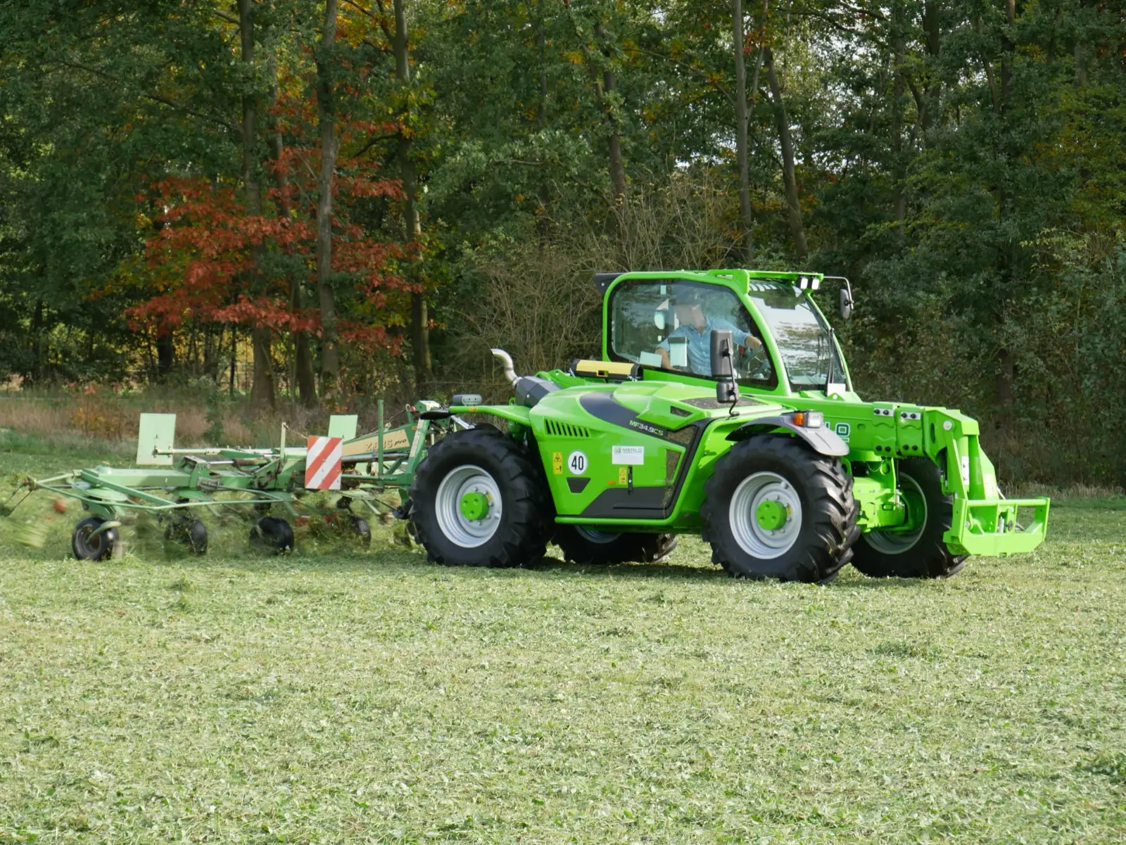 Baureihenbild zu Merlo MF 34.9 CS-140-CVTRONIC: Merlo Multifarmer MF 34 mit Schwader auf einer Wiese