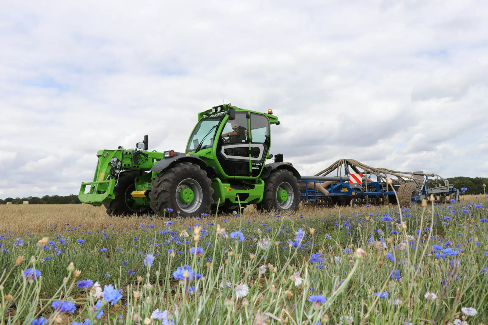 Merlo Multifarmer MF 44 mit Grubber am Rand eines Blumenfelds