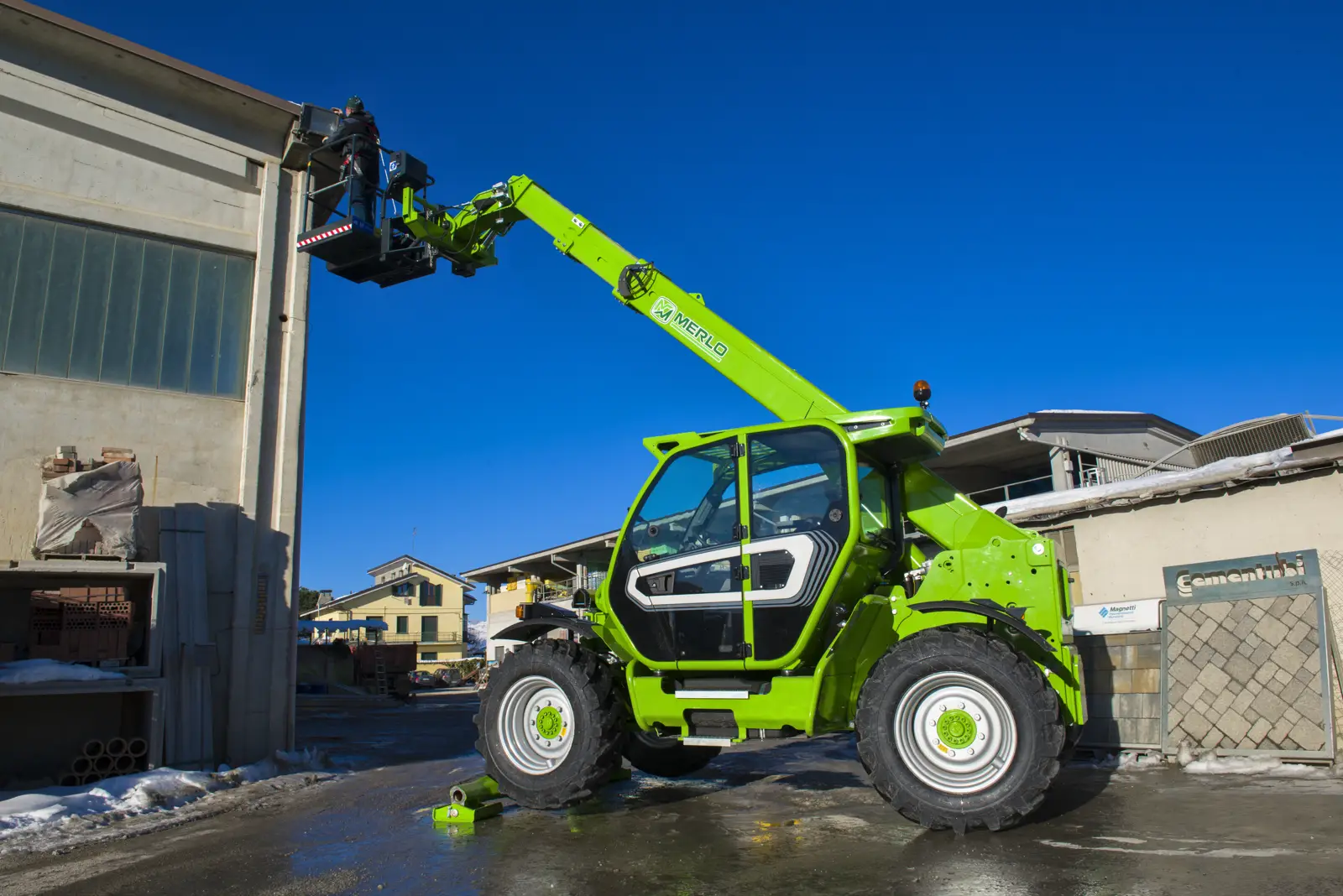 Merlo P35.11 TT hebt eine Arbeitsbühne an eine Hauswand