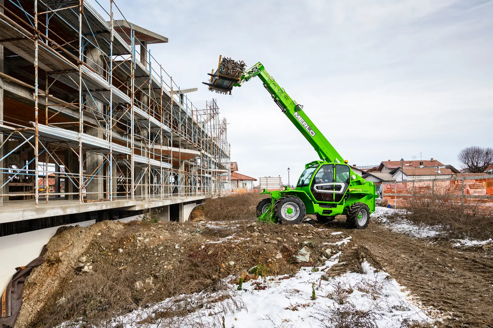 Merlo Panoramic 40.17 reicht eine Palette an ein eingerüstetes Gebäude
