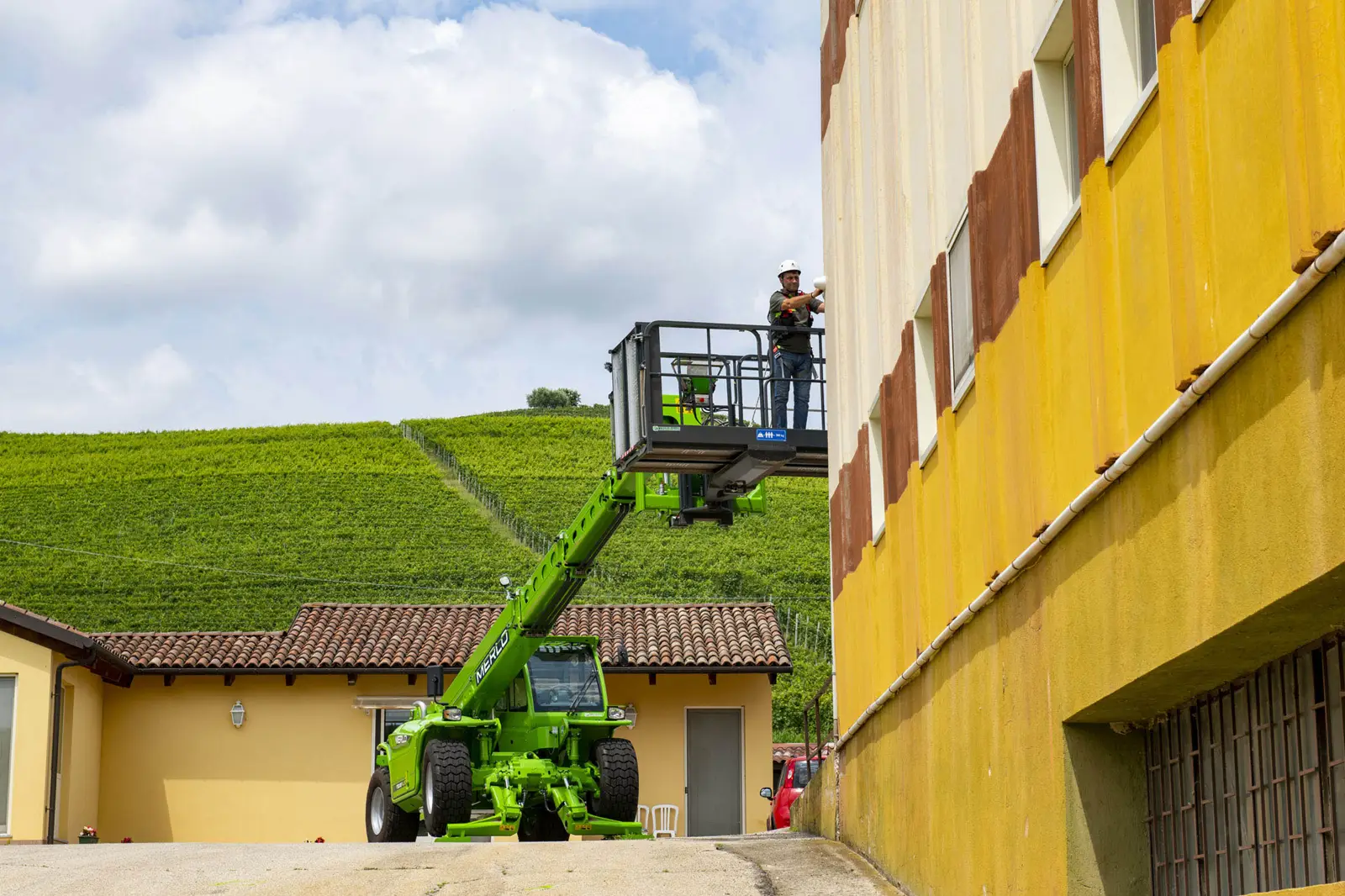 Merlo Panoramic 50.18 mit Arbeitsbühne an einer Hauswand