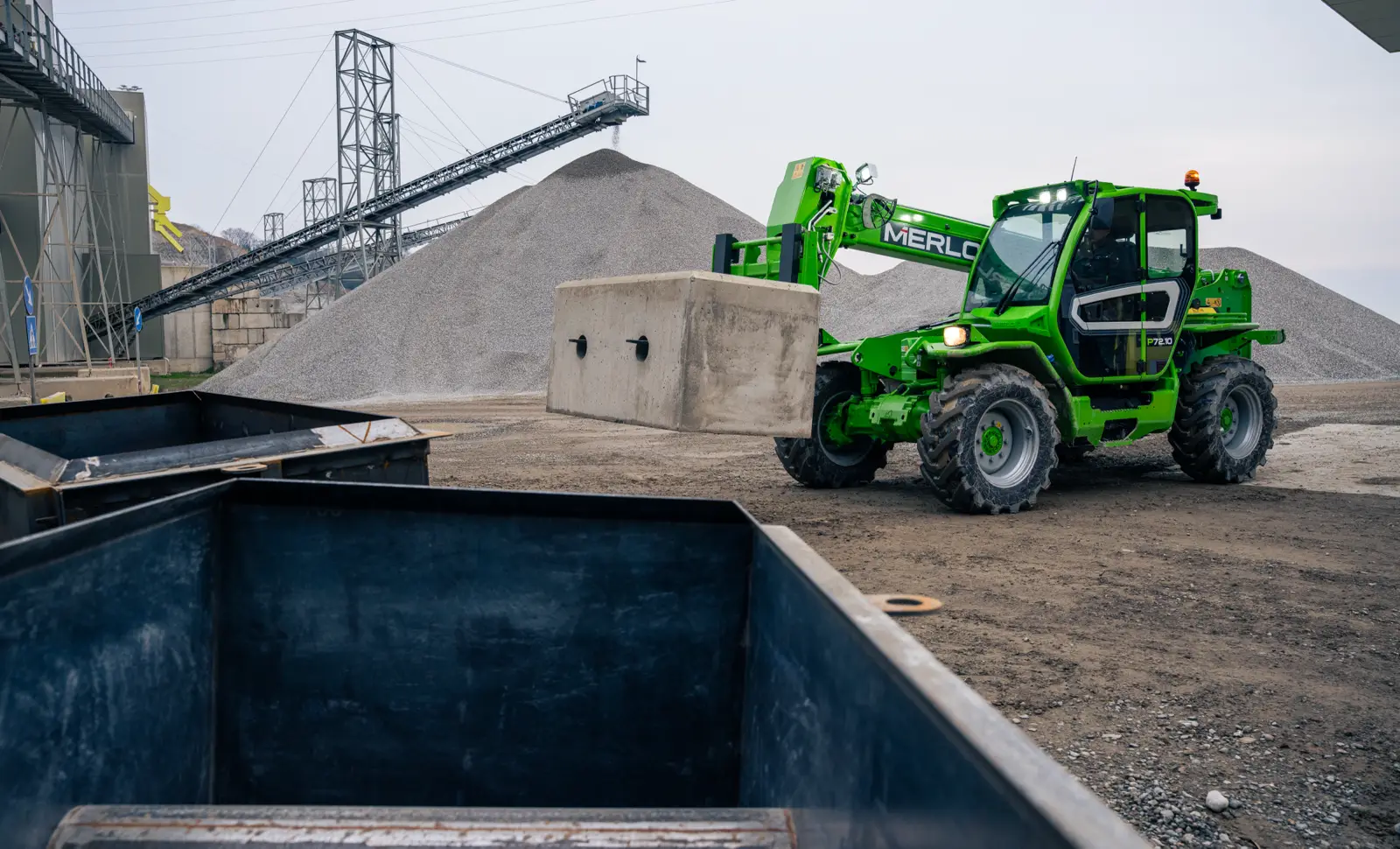 Merlo P72.10 trägt einen Betonblock auf einem Schotterwerk
