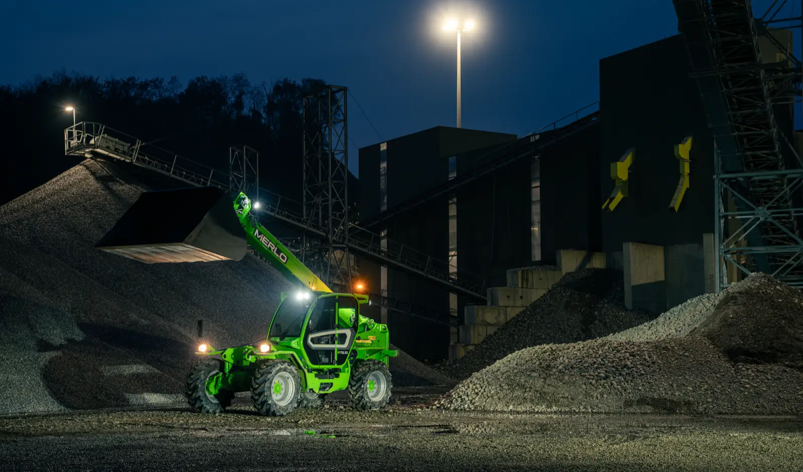 Merlo P72.10 mit angehobenem Ausleger bei Nacht
