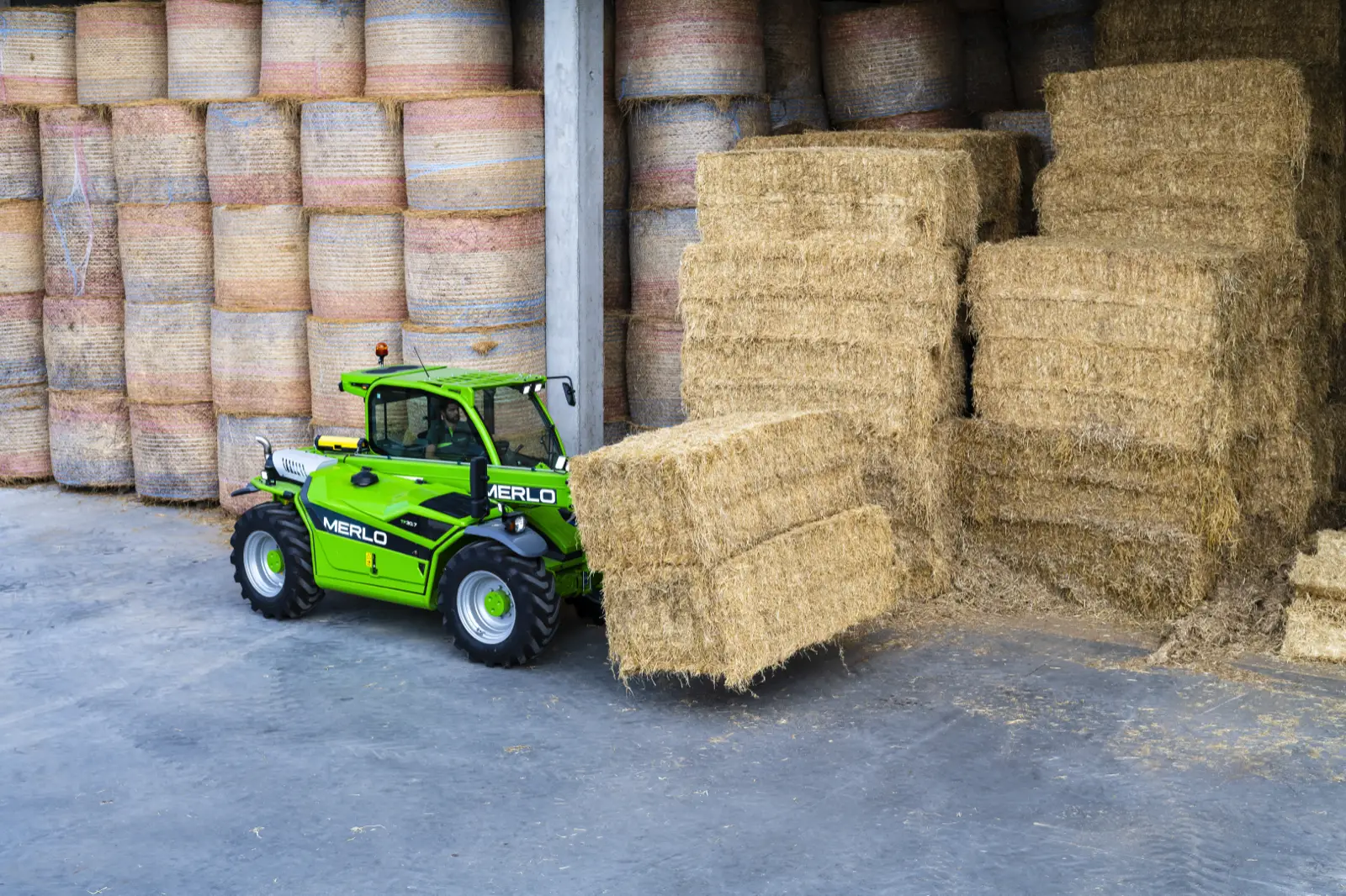 Baureihenbild zu Merlo TF 30.7: Merlo TF30.7 hebt Quaderballen in einer offenen Lagerhalle