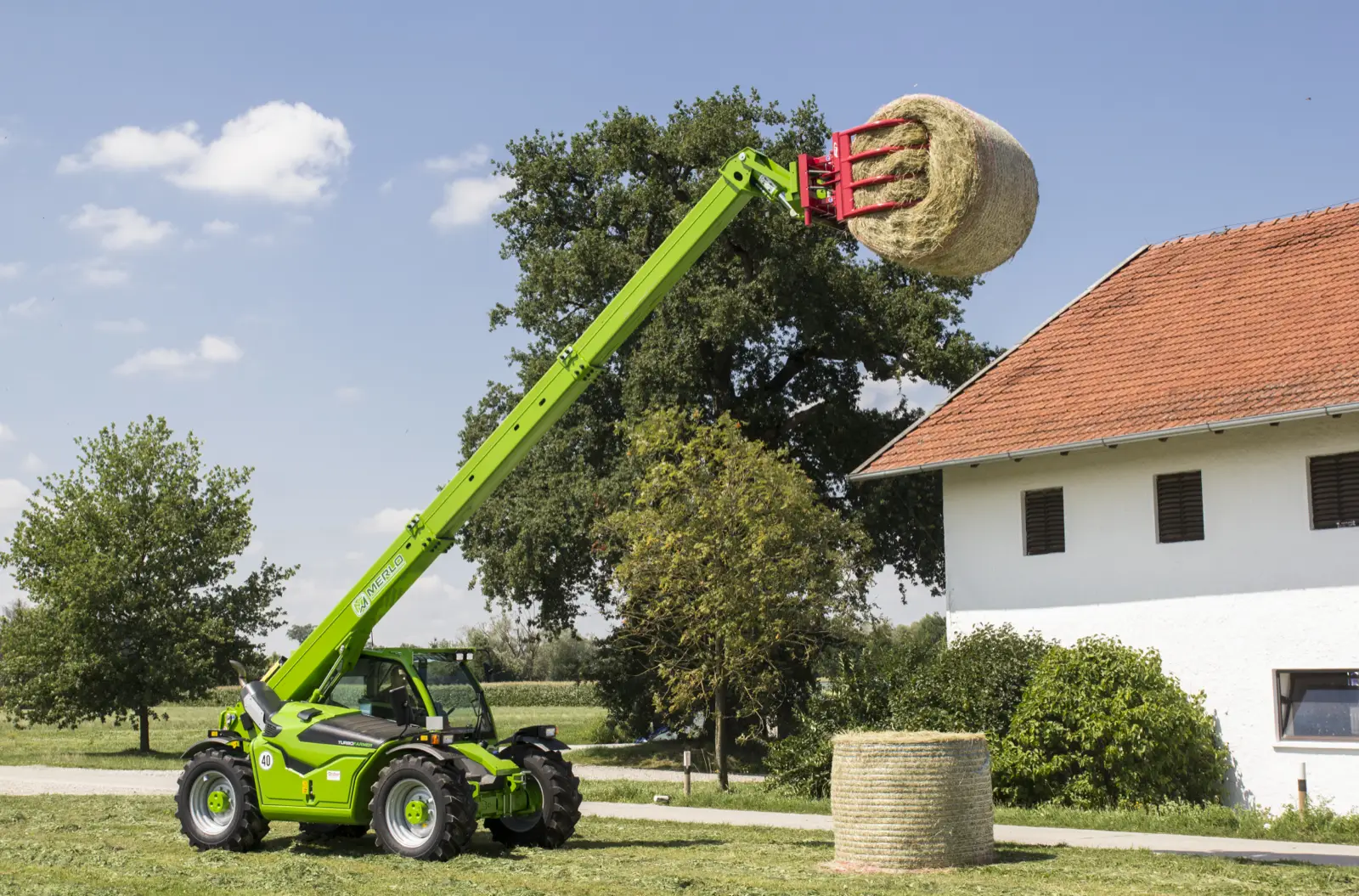 Baureihenbild zu Merlo TF 30.9 G: Merlo Turbofarmer der Baureihe TF30.9 hebt einen Rundballen mit weit ausgefahrenem Arm