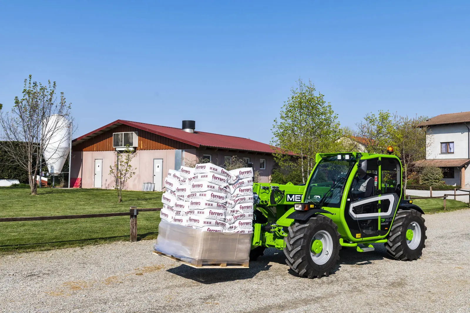 Baureihenbild zu Merlo TF 33.7 G: Merlo TF33.7 fährt Sackware auf einer Palette über einen Hof