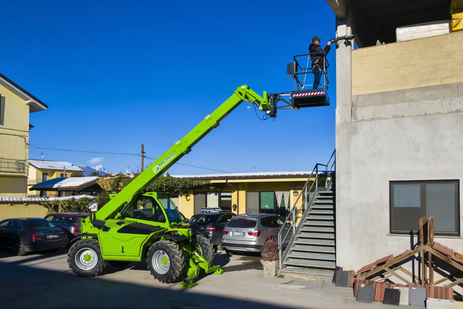 Merlo Teleskoplader der Baureihe 35.11 mit Personen-Arbeitsbühne an einer Hauswand