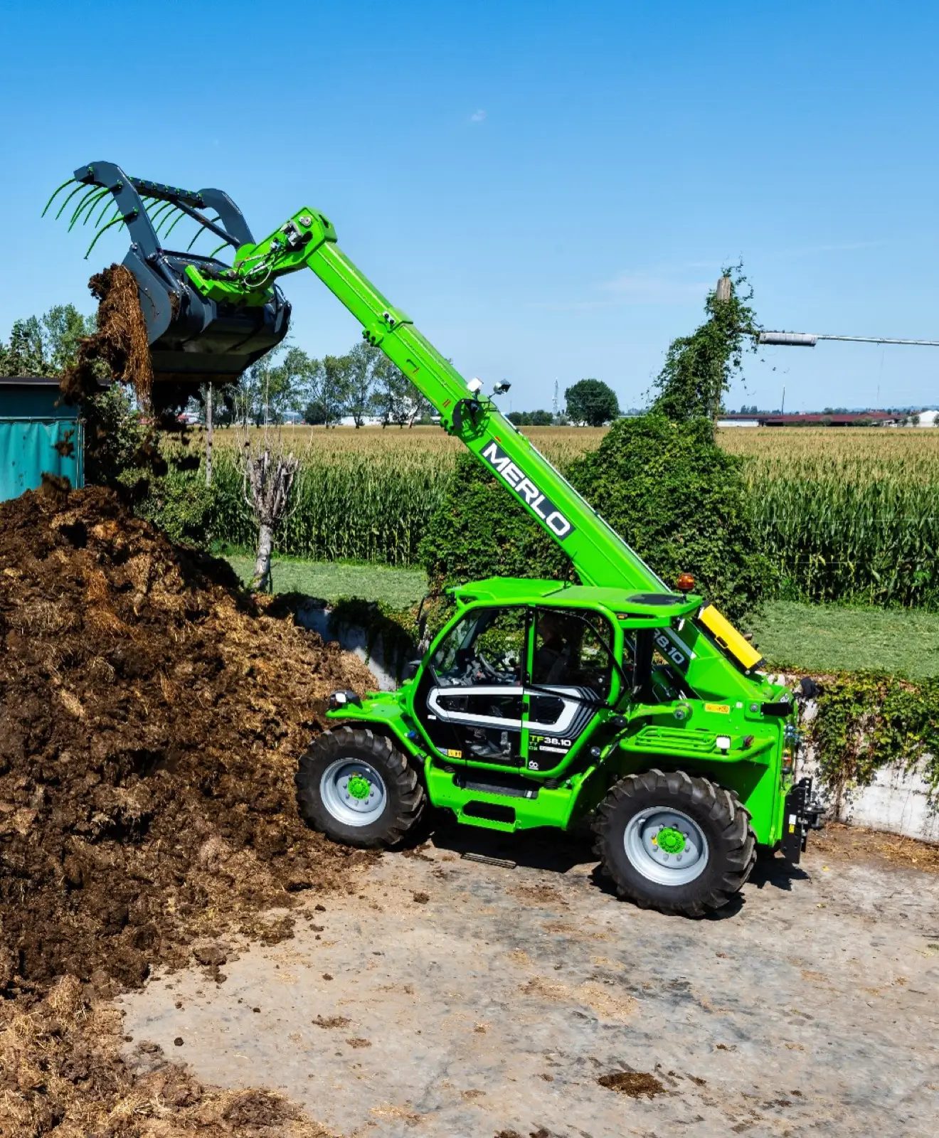 Baureihenbild zu Merlo TF 38.10 CS-136-CVTRONIC: Merlo TF38.10 mit Dunggabel an einem Misthaufen