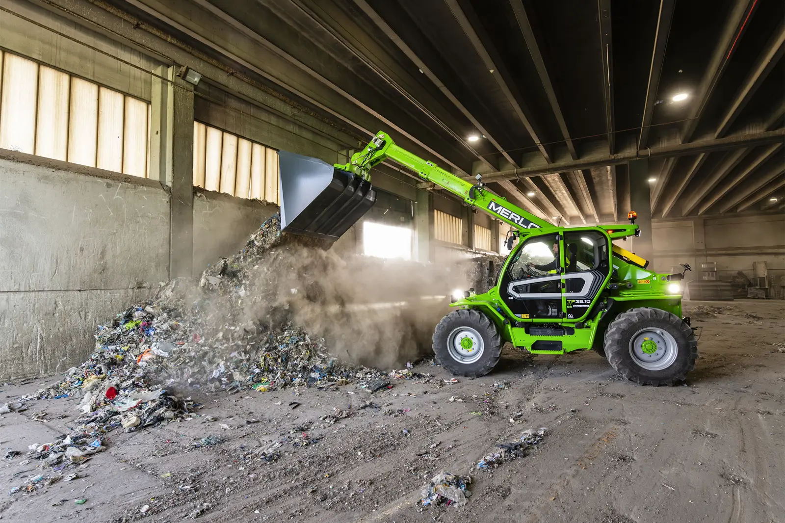 Baureihenbild zu Merlo TF 38.10 CS-136-CVTRONIC: Merlo TF38.10 mit Schaufel in einer Recyclinghalle