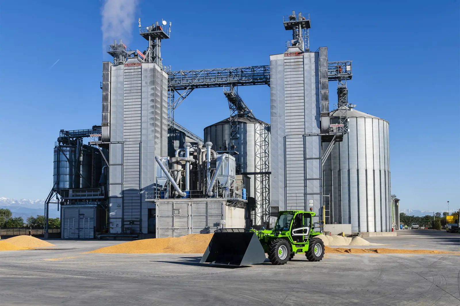 Baureihenbild zu Merlo TF 42.7 CS-136-CVTRONIC: Merlo TF42.7 mit Schaufel vor einer Siloanlage