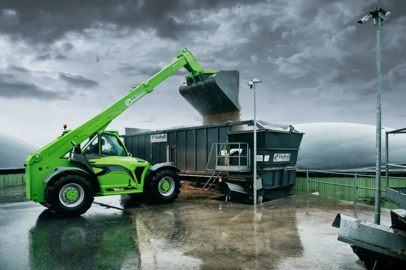 Baureihenbild zu Merlo TF 65.9 T-CS-170-CVTRONIC-HF: Merlo TF65.9 füllt mit ausgefahrenem Teleskoparm einen Container