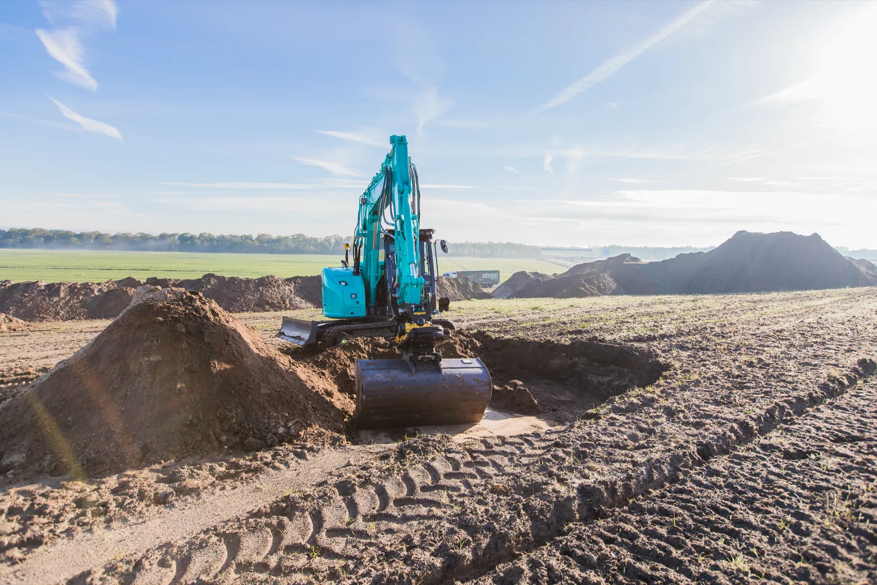 Kobelco SK75SR mit Planierschild beim Ausheben einer Grube