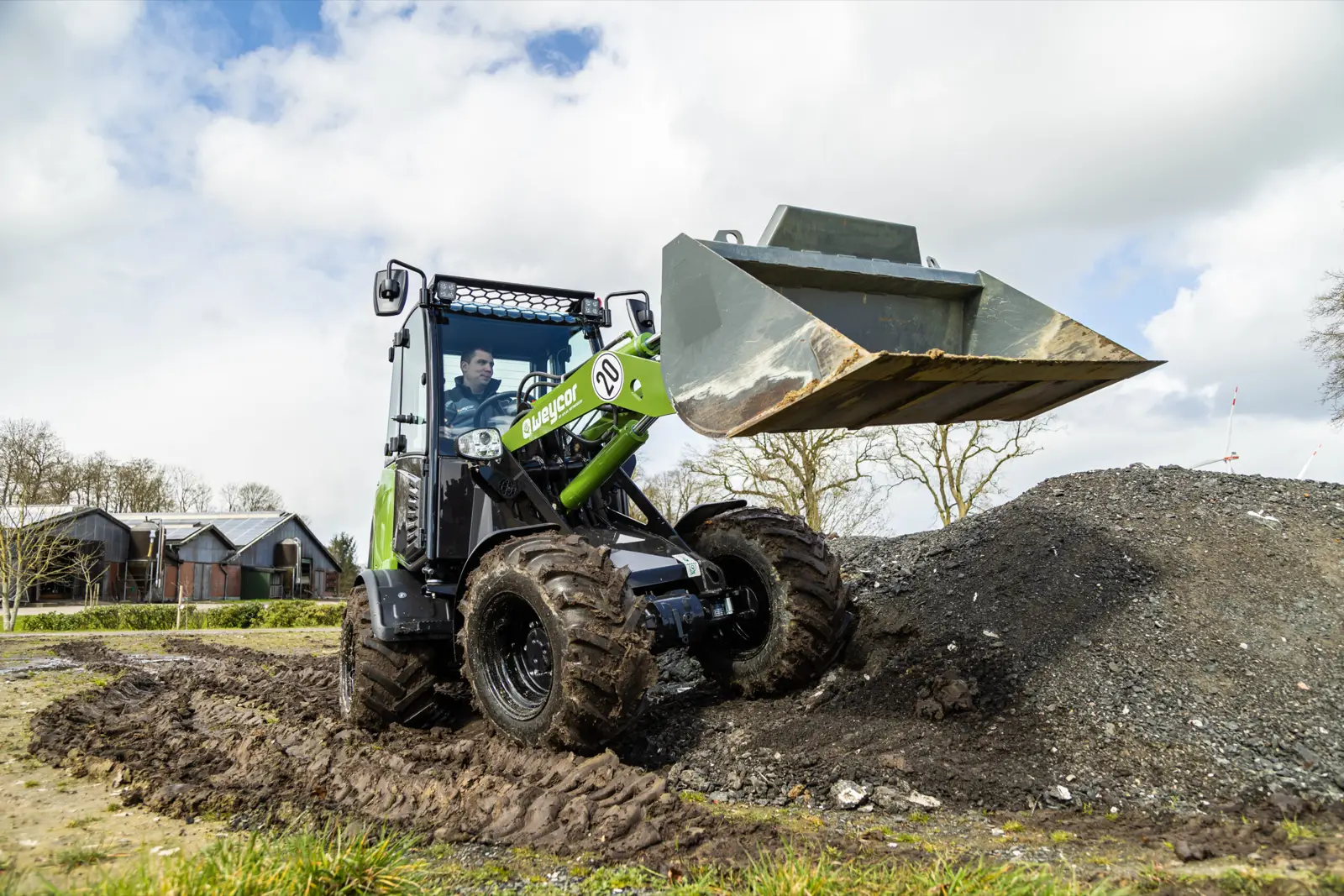 Weycor 380 Agrarline mit angehobener Schaufel an einem Erdhaufen