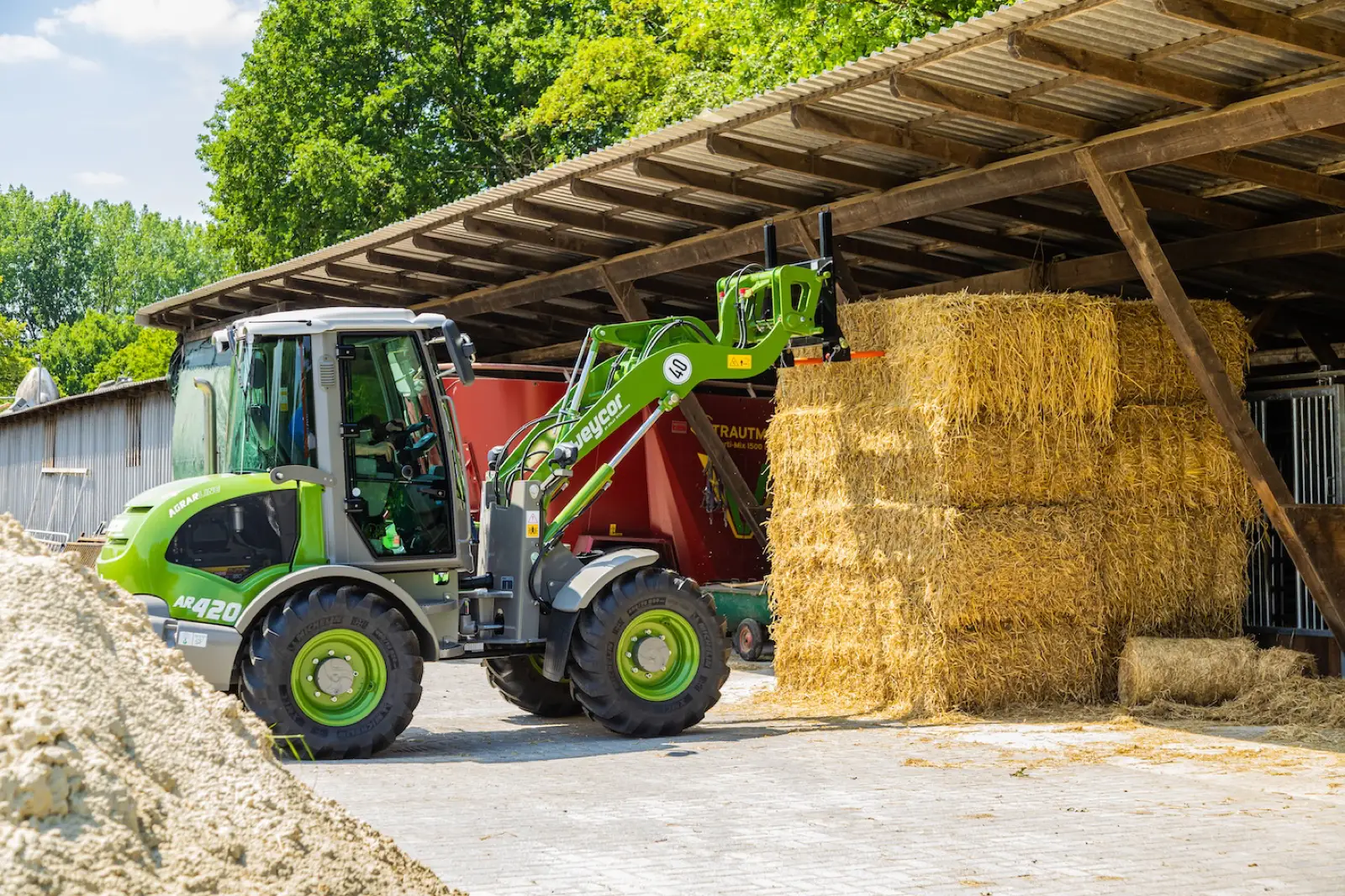Weycor AR420 Agrarline stapelt Strohballen unter einem Vordach