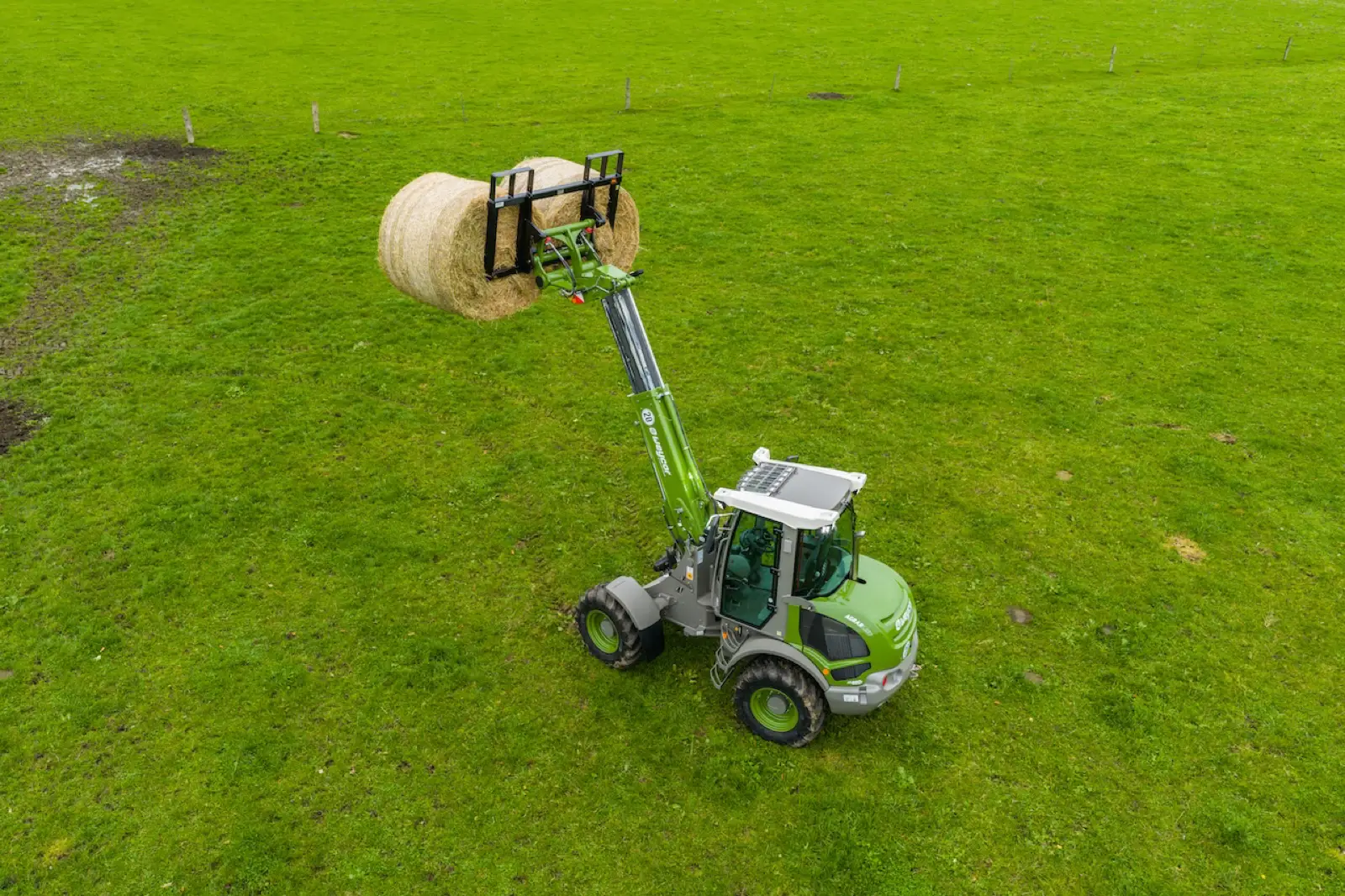 Weycor AR480T Agrarline mit ausgefahrenem Arm auf einer Weide, von oben