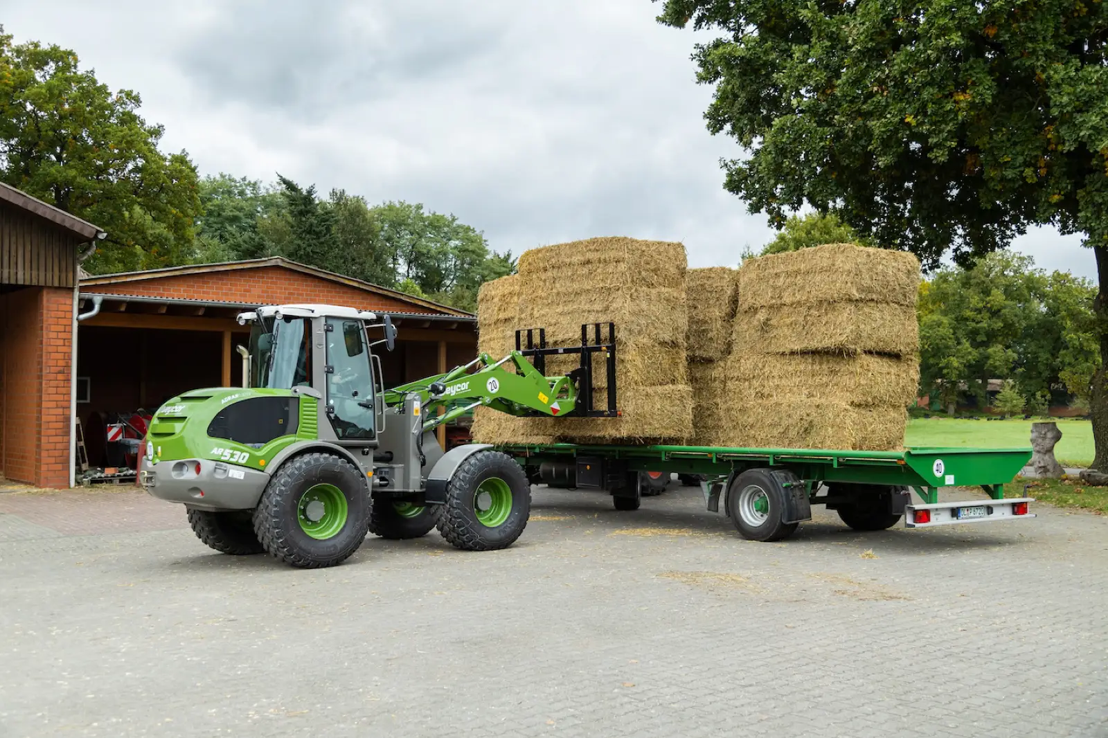 Weycor AR530 Agrarline belädt einen Anhänger mit Strohballen
