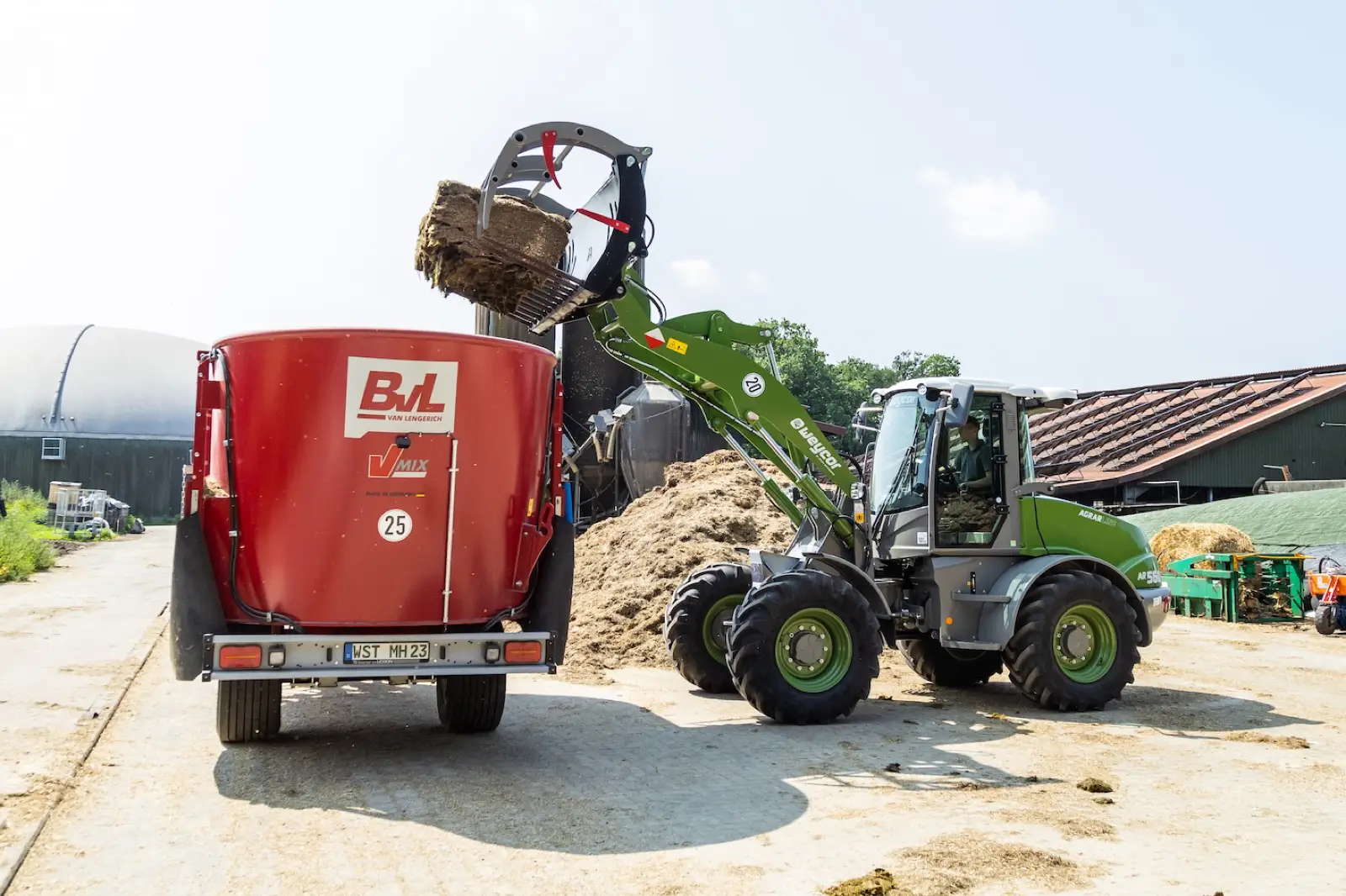 Weycor AR560 Agrarline befüllt einen Futtermischwagen mit der Greifschaufel