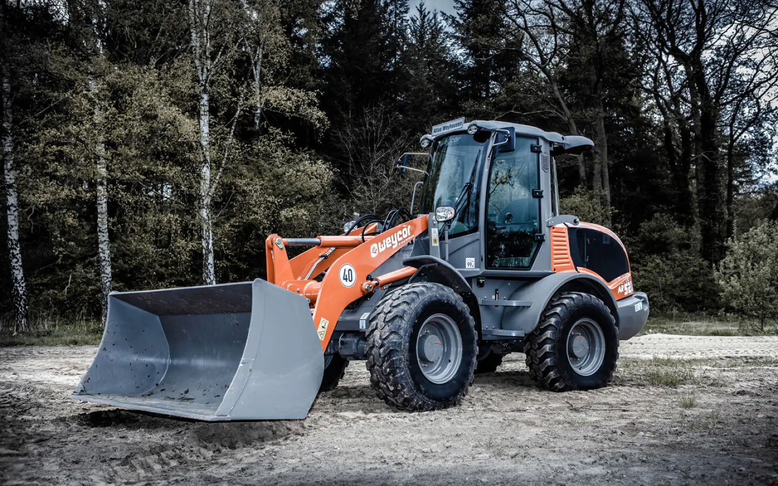 Weycor AR520 mit großer Schaufel vor Bäumen