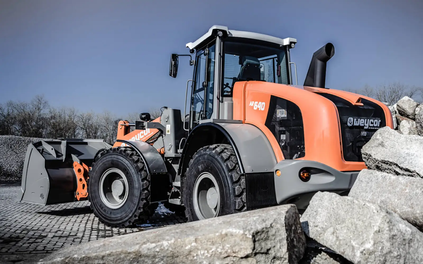 Weycor AR640 mit Schaufel zwischen großen Steinblöcken