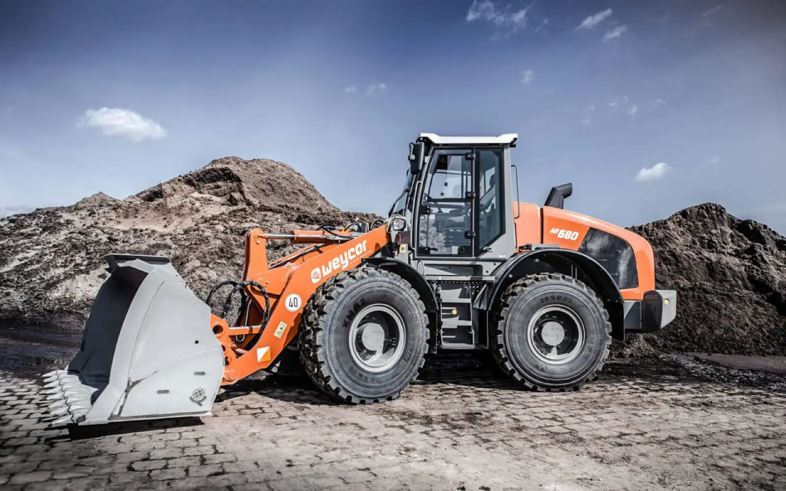 Weycor AR680 mit Schaufel vor einem Erdhaufen
