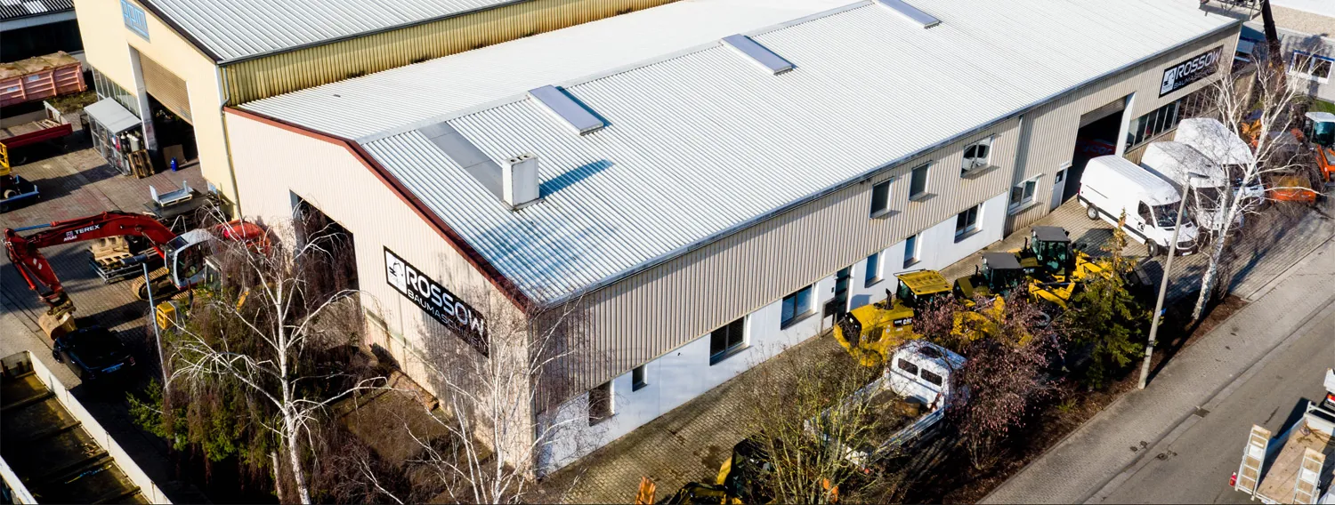 Luftbild der Halle von Rossow Baumaschinen in der Industriestraße 24 mit Firmenschild